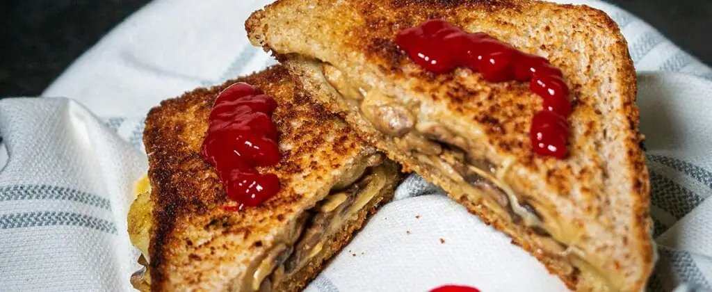 Tosty pełnoziarniste z serem i pieczarkami z keczupem jako przykład co zjeść po treningu